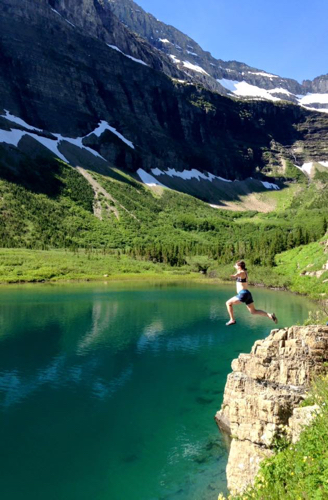 hiker jumping into Glacier Pond